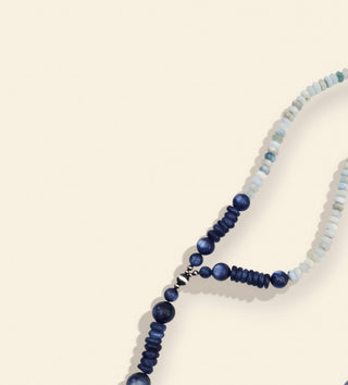 Blue beaded necklace on a beige background
