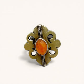 A vintage-style silver ring with an ornate filigree design and a central oval amber gemstone, shown on a plain off-white background.