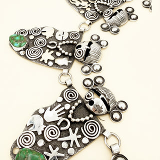 Silver jewelry with various designs and green stones on a white background