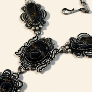 Decorative black and silver necklace on a light background