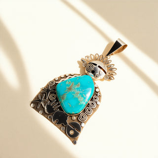 Turquoise pendant with intricate designs on a beige background