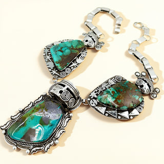 Turquoise necklace with warrior and maiden on a beige background