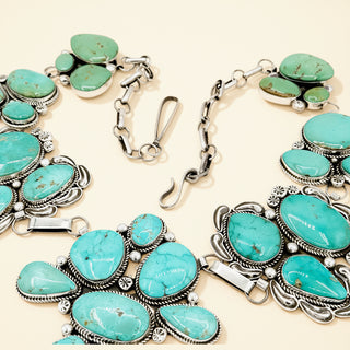 Turquoise jewelry with silver accents on a beige background