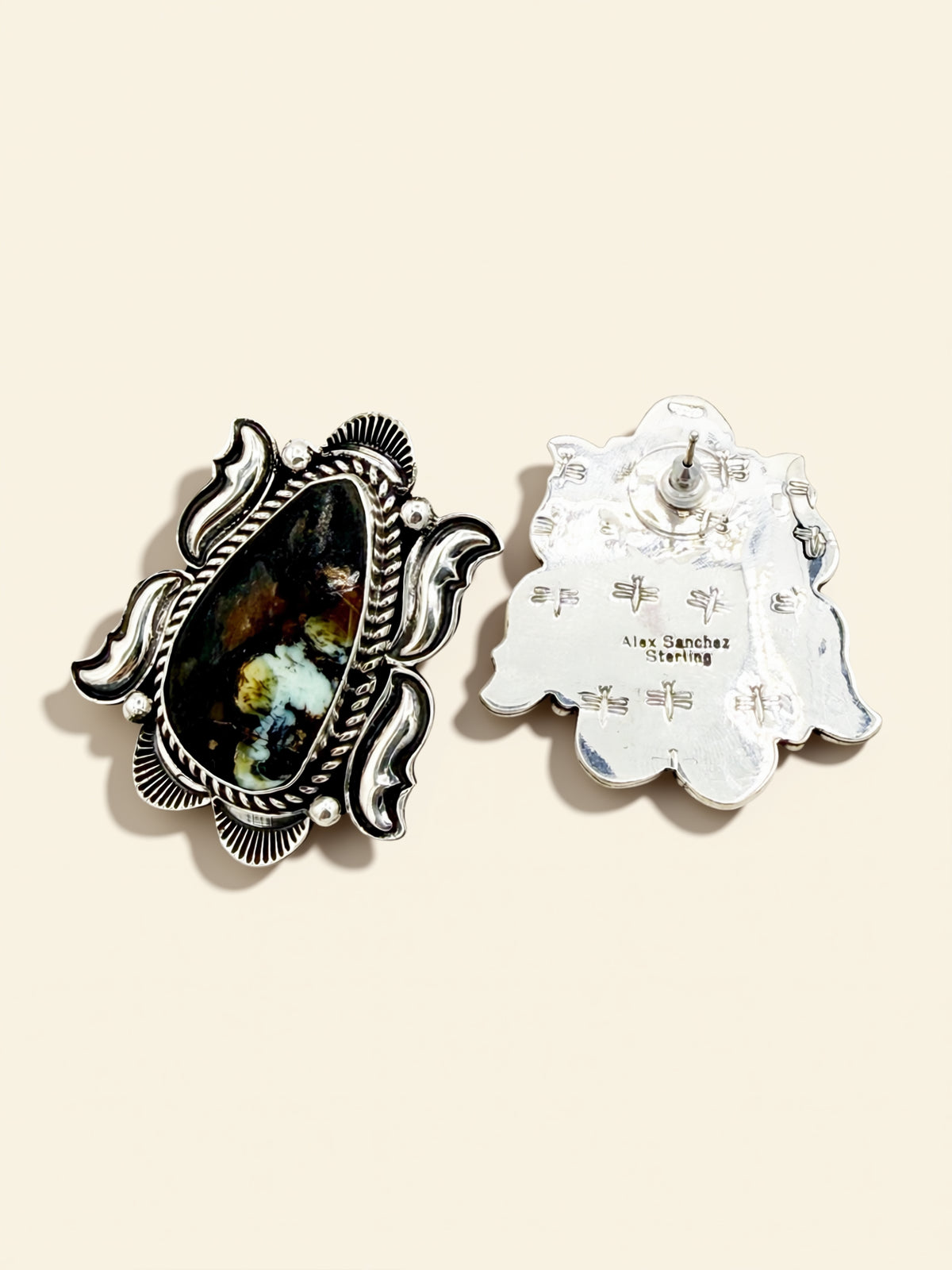 Two decorative earrings on a beige background