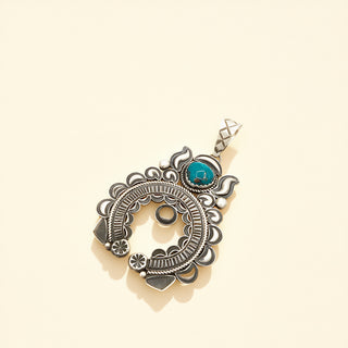 Silver pendant with turquoise stone on a beige background