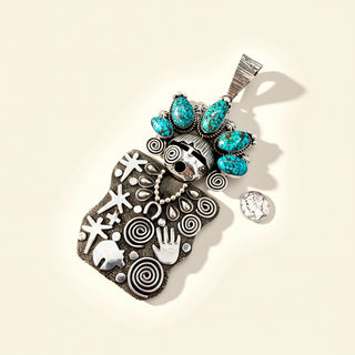 Decorative pendant with turquoise stones and intricate patterns on a beige background