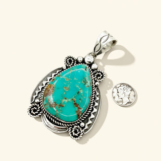 Turquoise pendant with silver frame on a white background