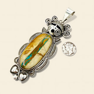 Silver pendant with a large stone and decorative elements on a beige background