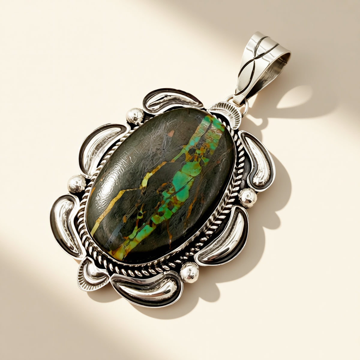 Silver pendant with an oval stone on a beige background