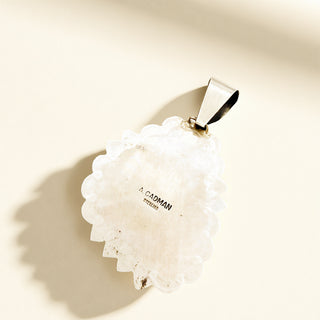 Silver pendant with stamp on a beige background