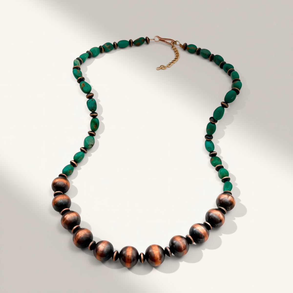 Necklace with green and brown beads on a light gray background