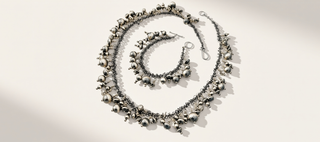 Silver necklace and bracelet set on a light background