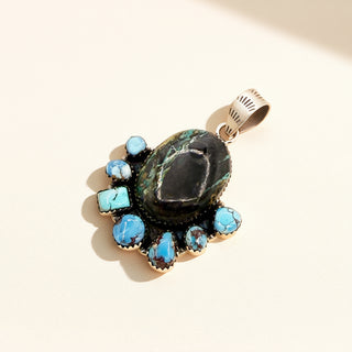 Jewelry pendant with turquoise stones on a light background
