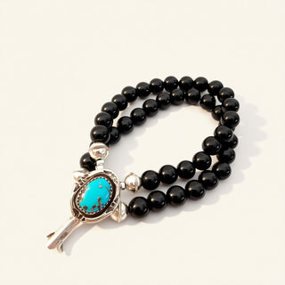 Black beaded bracelet with a turquoise and silver clasp on a white background