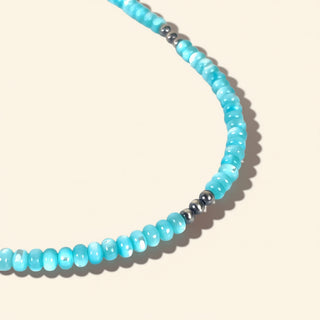 Necklace with blue beads on a beige background