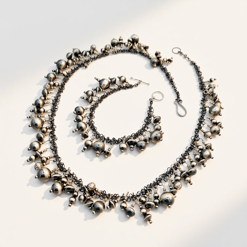 Silver necklace with hanging beads on a light background