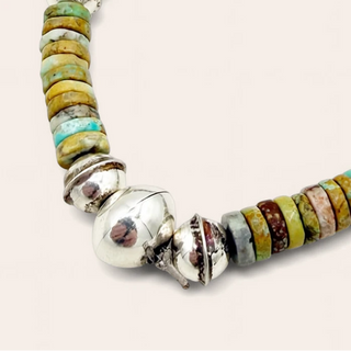 Multicolored beaded bracelet with silver accents on a light beige background