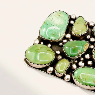 Jewelry with green stones and silver accents on a white background