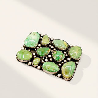 Jewelry with green stones and silver accents on a white background