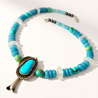 beaded turquoise necklace with pendant on a beige background