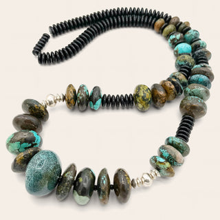 Necklace with black and turquoise beads on a white background