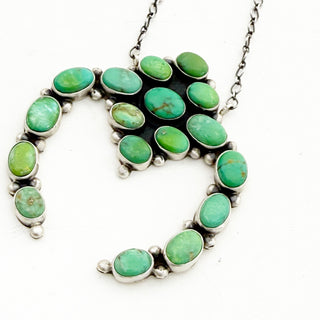 Necklace with green stone pendant on a white background