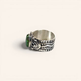 Silver ring with green stone on a white background