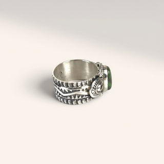 Silver ring with multiple bands and a pendant on a light gray background