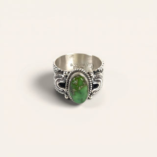 Silver ring with a green stone on a white background