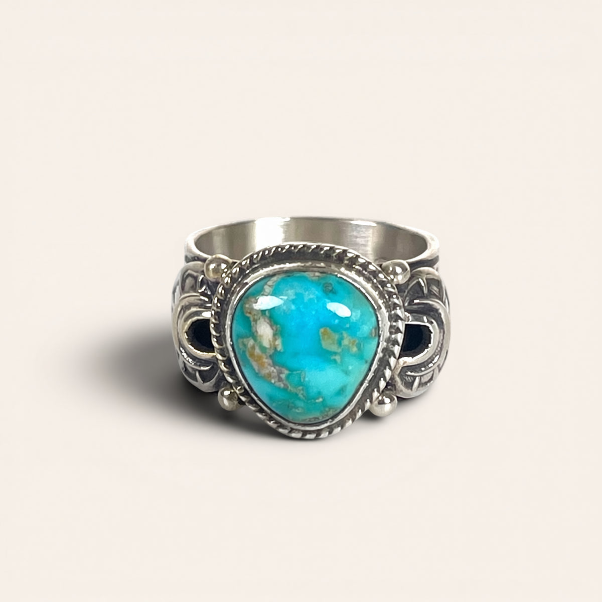 Silver ring with a turquoise stone on a light background