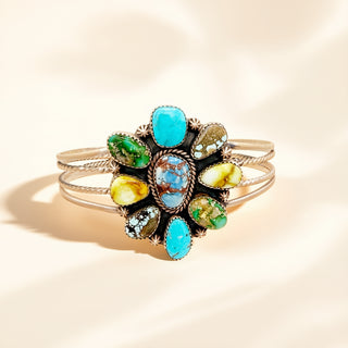 Silver ring with multi-color stone on a beige background