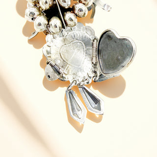 Silver locket with heart charms on a light background