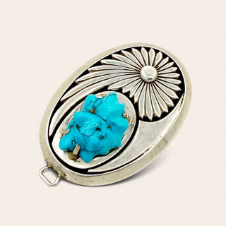 Silver and turquoise decorative item on a beige background