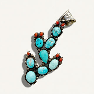 A silver-toned cactus-shaped pendant featuring multiple oval turquoise-blue stones and small coral-red accents, photographed on a clean off-white background.