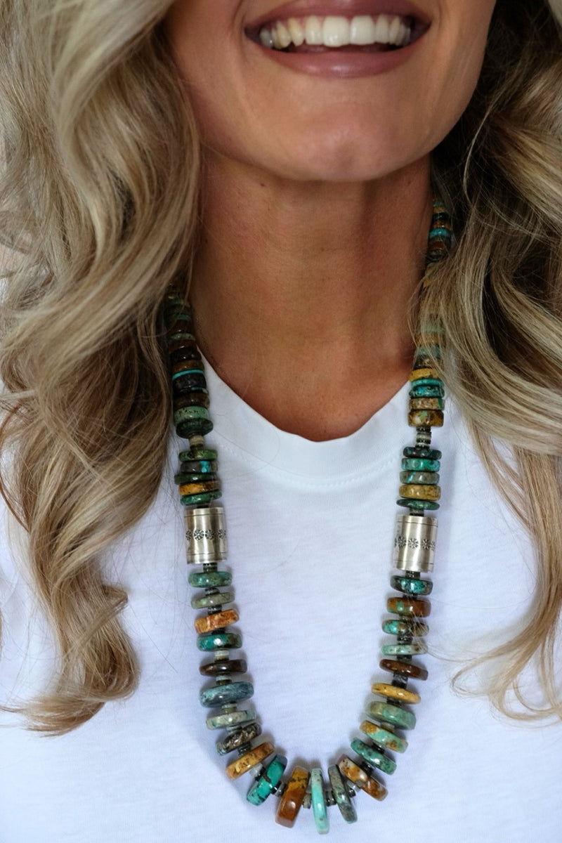 Close-up of a person wearing a colorful beaded necklace on a white background