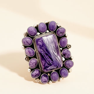 Purple stone ring with decorative setting on a beige background