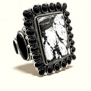 Decorative cuff with black stones and a central stone on a white background