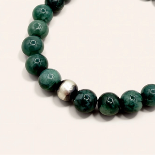 Green beaded bracelet on a white background