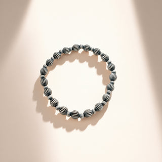 Black beaded bracelet on a beige background