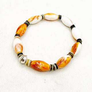 Bracelet with orange, white, and black beads on a white background