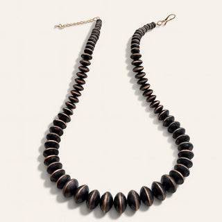 Necklace with dark brown beads on a light gray background