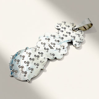 silver pendant on a beige background
