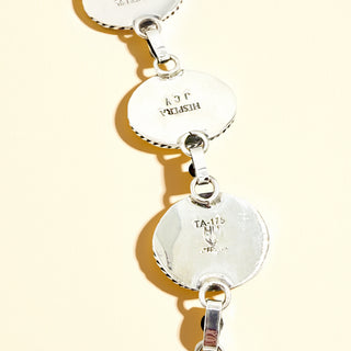 Close-up of necklace with engraved text on a light background