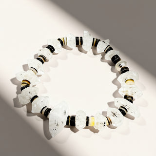 White beaded bracelet with black and gold accents on a light background