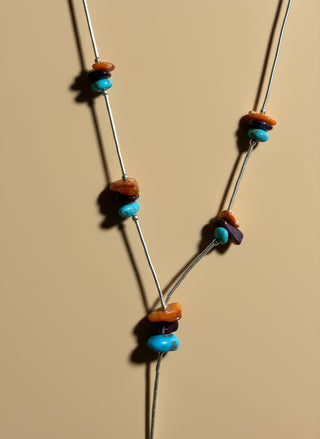 Necklace with colorful beads on a tan surface