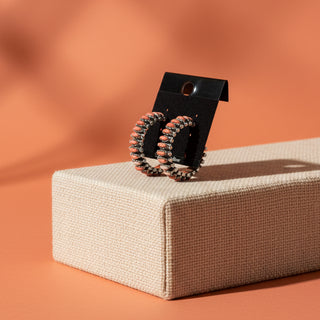 Pair of colorful hoop earrings on a black card 