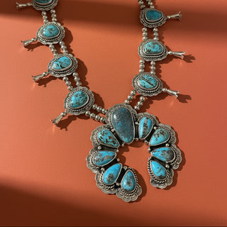 Turquoise squash blossom with ornate silver detail