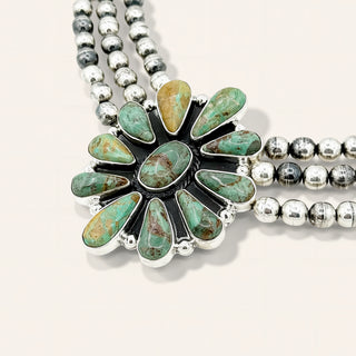 Necklace with turquoise stones and silver beads on a white background