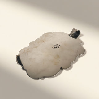 silver pendant with  silver bail on a light gray background