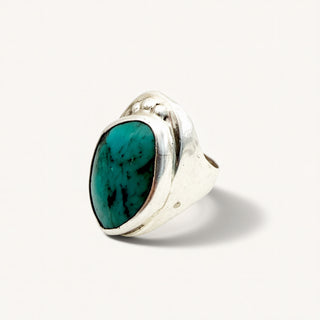 silver ring with turquoise stone on a beige background
